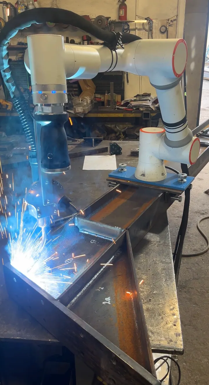 Cobot spawalniczy prowadzi palnik MIG/MAG wzdłuż złącza stalowego profilu
